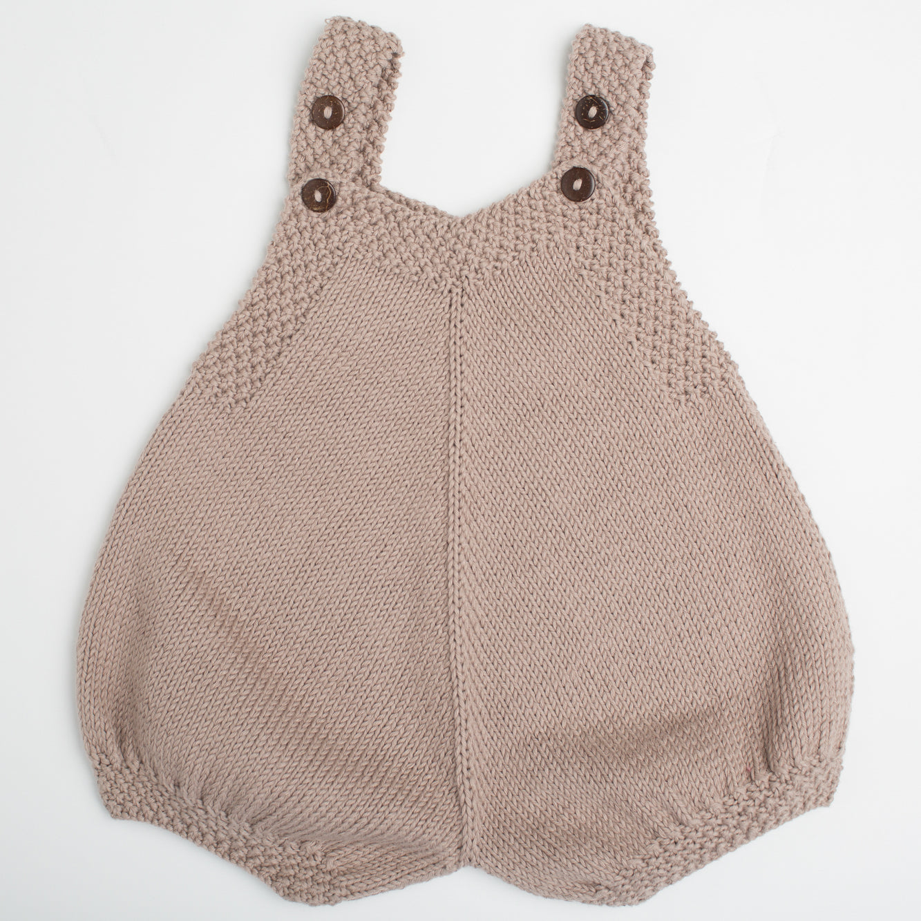 Finn Baby Romper in beige, hand-knitted with cotton yarn, featuring wooden button straps and a cozy chunky texture, ideal for newborns.